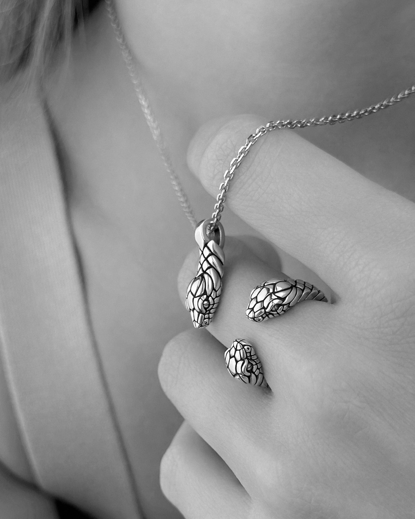 Silver snake charm necklace and complimenting ring on model