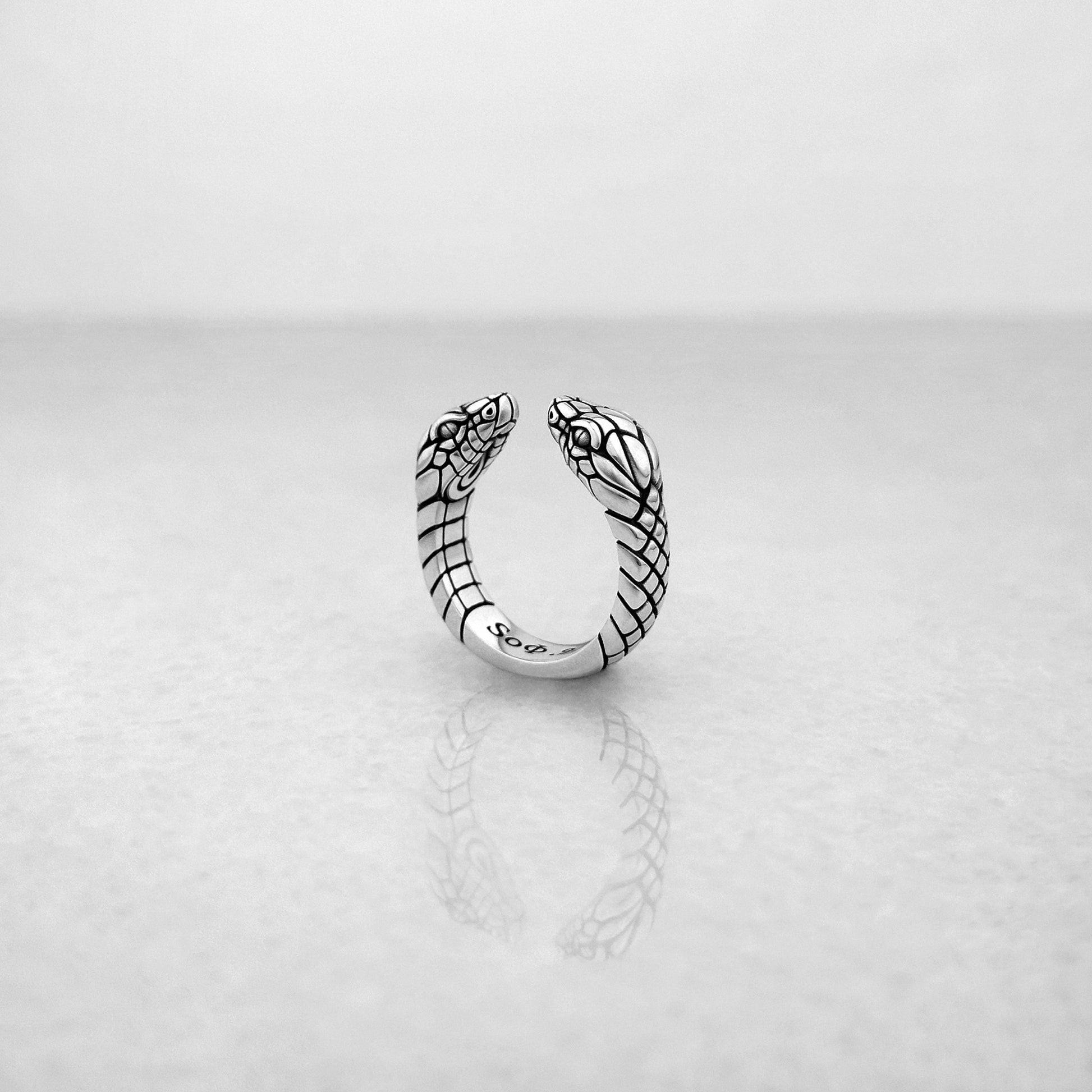 Edgy silver open ring with two snake heads